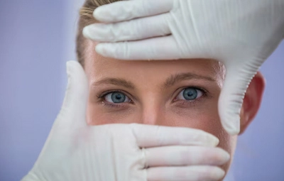 Yeux d'une femme entre deux mains gantées