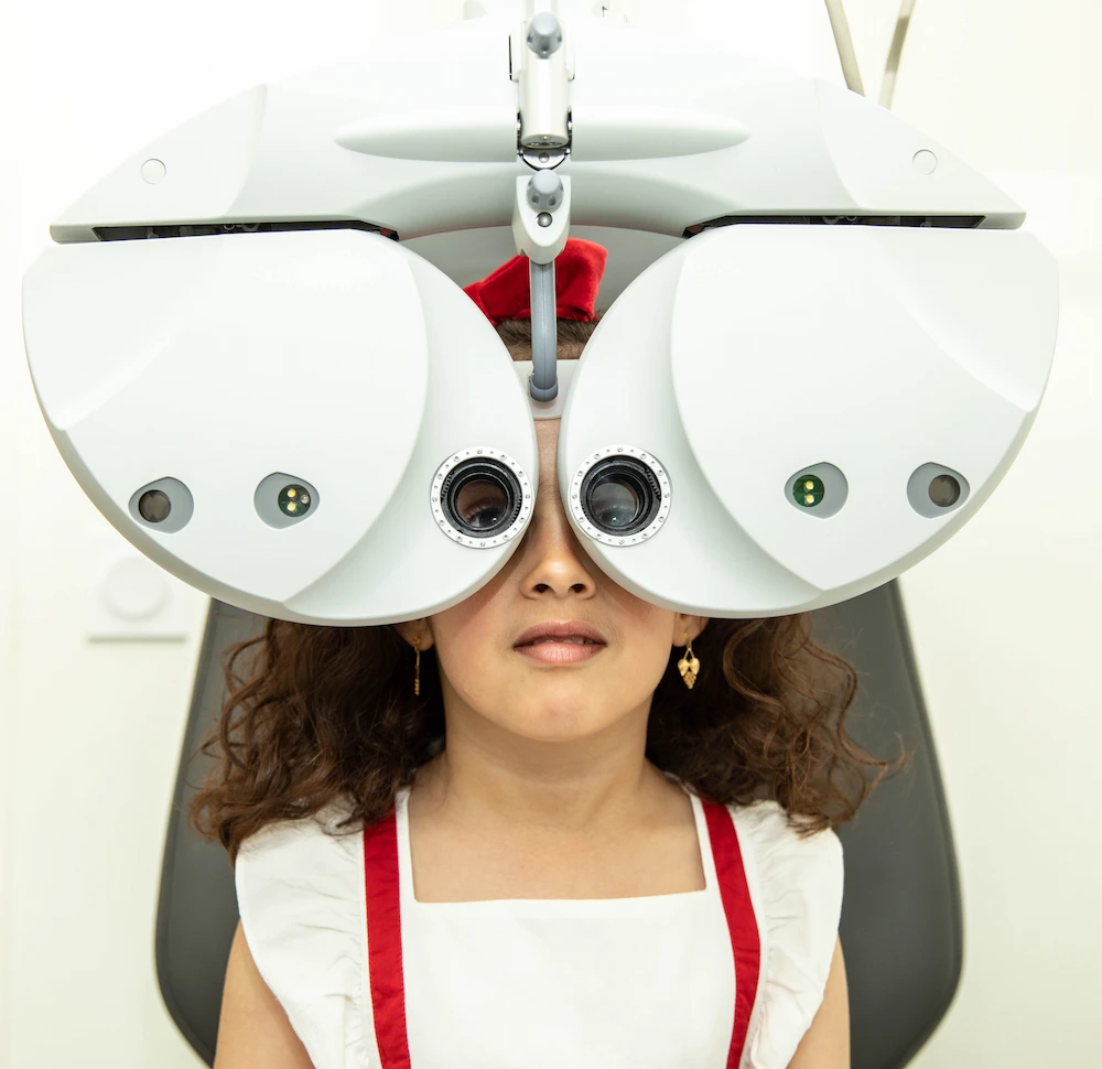 clinique-de-la-vue-examen-vue-refractometre-frontal-enfant-consultation-ophtalmologique-pediatrique-lyon-roanne-givors Examen de vue chez une enfant à la Clinique de la Vue Lyon lors d’une consultation d’ophtalmologie pédiatrique