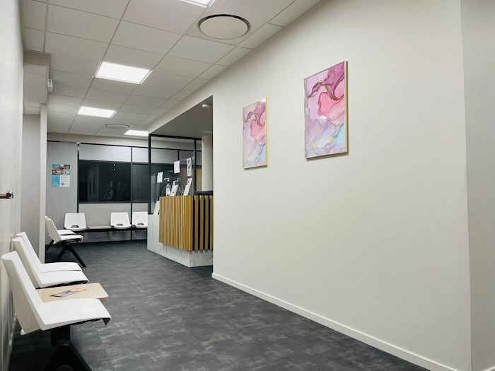 clinique-de-la-vue-givors-salle-attente-tableaux-roses-accueil-ophtalmologie-chasse-sur-rhone-69 Salle d’attente moderne de la Clinique de la Vue à Givors avec espace d’accueil et consultations ophtalmologiques