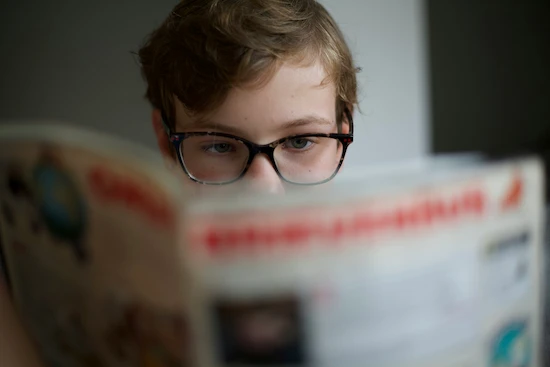 Enfant ayant une hypermétropie en train de lire